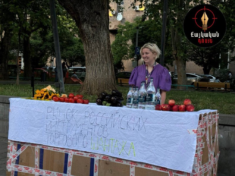 Ироничная инсталляция на Вернисаже в Ереване с помидорами, баклажанами, цветами и бутылками Джермука, высмеивающая торговый